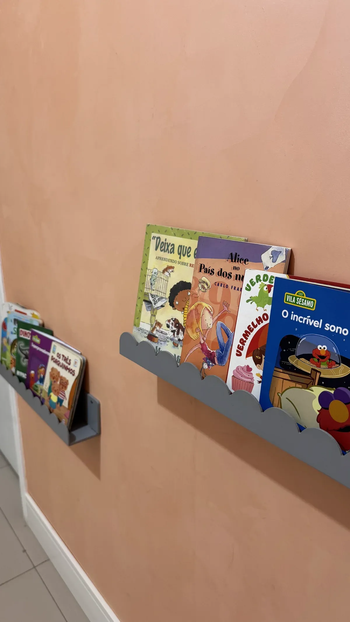 Prateleiras com livros infantis na parede da sala de atendimento