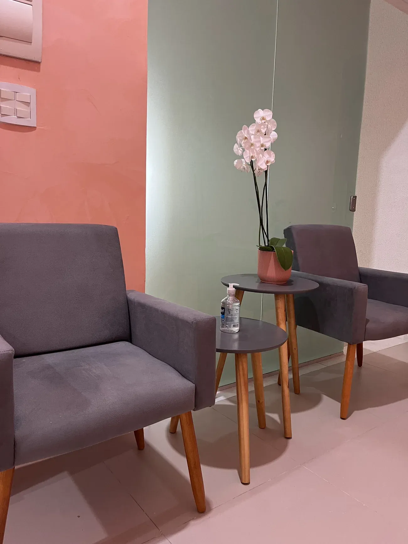 Recepção do Espaço Akatu, com poltronas, mesa de apoio e orquídea